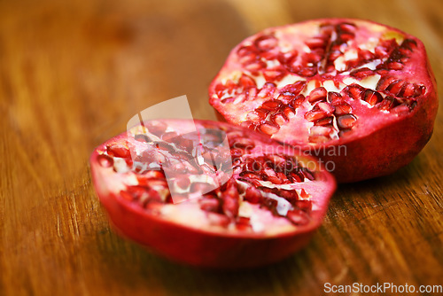 Image of The sweet little gems within. a pomegranate that has been cut in half.