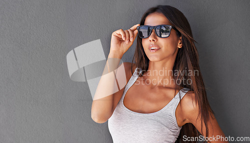 Image of Shes sexy and she knows it. a sexy young woman wearing sunglasses.