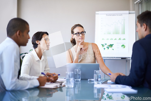 Image of Discussing their figures for the year. A group of businesspeople having a meeting.