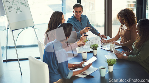 Image of Delegating tasks to achieve success as a team. a group of businesspeople having a meeting in an office.