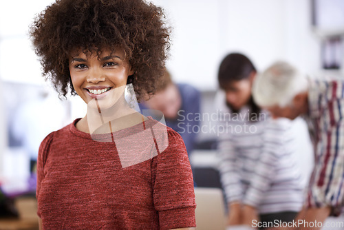 Image of I get to use my imagination in this job. Portrait of an attractive young businesswoman with her colleagues in the background.