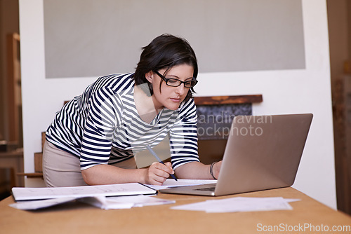 Image of Dreams dont work unless you do. A cropped shot of a woman standing at her desk and working on her laptop.