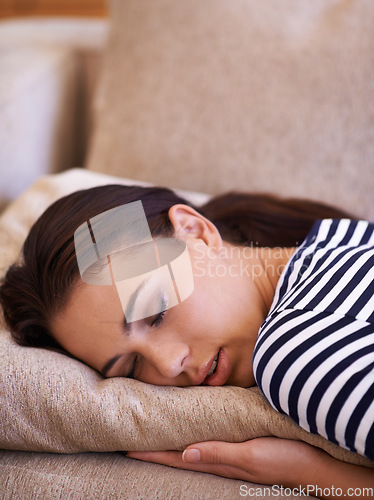 Image of Fast asleep. an attractive young sleeping on her sofa at home.