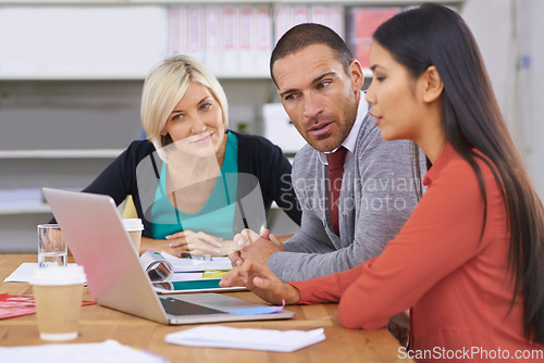 Image of Itd be good to hear your thoughts on this...Three coworkers brainstorming around a laptop.