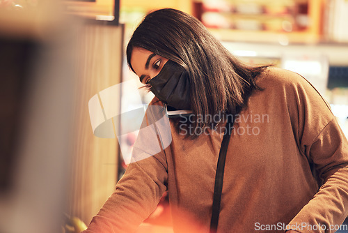 Image of What are you craving for dinner. a young woman making a phone call while doing her grocery shop.