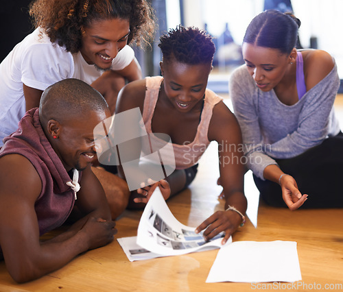 Image of Which dance routine should we try today. a group of young dancers looking through a catalogue of dance moves.