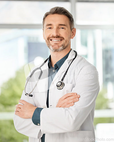 Image of Caring for you is simply what we do. a medical practitioner standing with his arms crossed in a hospital.