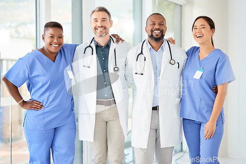 Image of Never fear, the doctors are here. a cheerful group of doctors standing with their arms around each other inside of a hospital during the day.