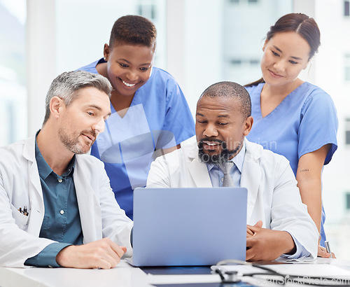 Image of Allowing open communication leads to better results. a group of young doctors looking at a laptop during a meeting in the hospital boardroom.