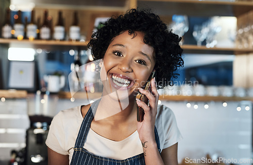Image of Putting in the hard work towards a profitable small business. Portrait of a young woman talking on a cellphone while working in a cafe.