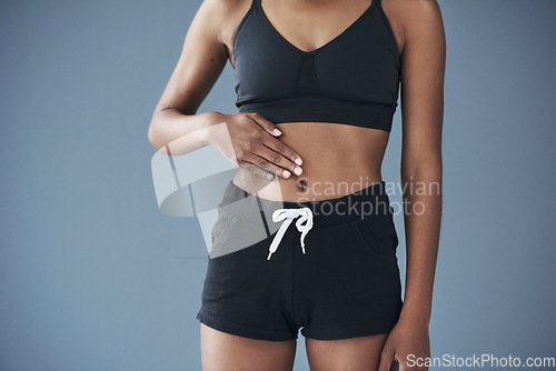 Image of Good health, you can feel it in your gut. Closeup shot of a sporty young woman posing with her hand on her stomach.