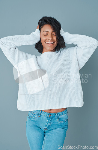 Image of Block out the haters. a beautiful young woman posing against a teal background.