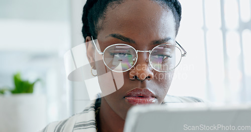 Image of Serious black woman, business and research on tablet, reading email on app and planning in creative startup office. Digital technology, professional and African designer working on internet project