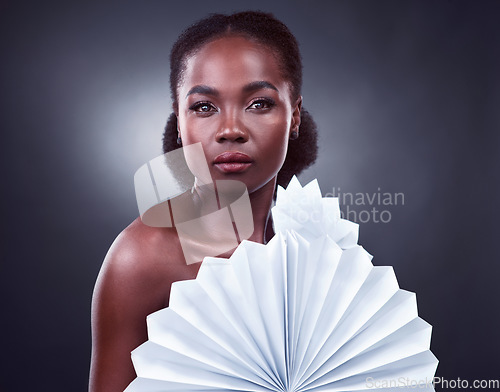Image of Im a big fan of natural beauty. Studio portrait of a beautiful young woman posing with origami fans against a black background.