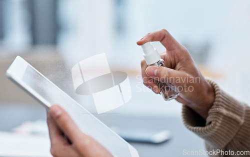 Image of Take down germs with just one spray. an unrecognisable man disinfecting his digital tablet while working from home.