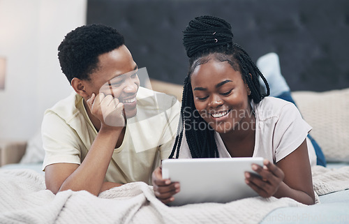 Image of Lockdown is fun when youre with your favourite one. a young couple using a digital tablet while relaxing on their bed at home.