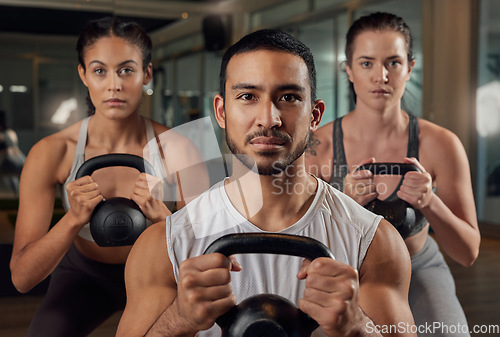 Image of Adding some weight to their workout. Cropped portrait of three young athletes working out with kettle bells in the gym.