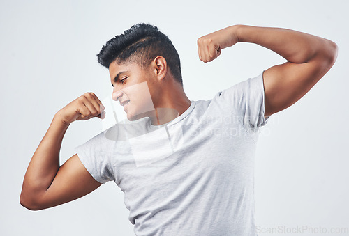 Image of You gptta hustle for some muscle. Studio shot of a young man flexing against a white background.