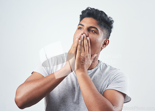 Image of Its just too good to be true. Studio shot of a young man sitting against a white background.