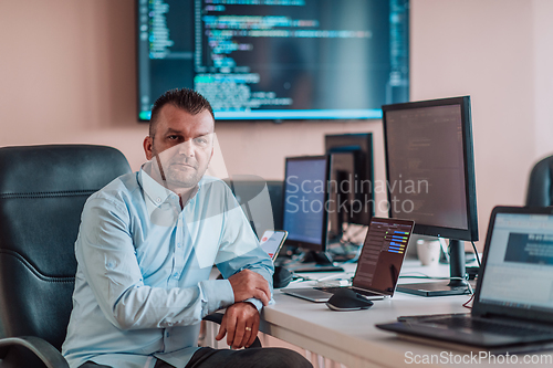 Image of A programmer diligently testing smartphone applications while sitting in their office.