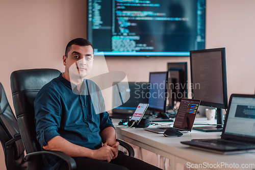 Image of A programmer diligently testing smartphone applications while sitting in their office.