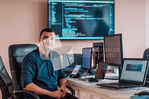 Image of A programmer diligently testing smartphone applications while sitting in their office.