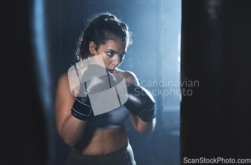 Image of She needed a hero, so thats what she became. a sporty young woman boxing in a gym.