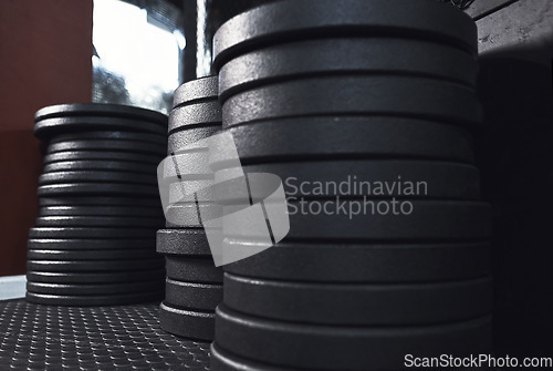 Image of It never gets easier, you just get stronger. Still life shot of weight plates in a gym.