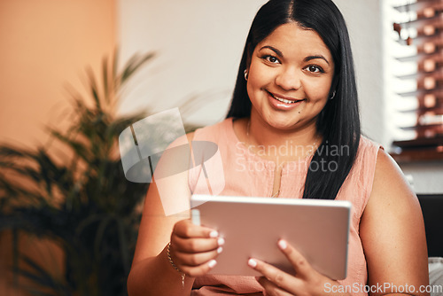 Image of Home is where I can browse in absolute leisure. Portrait of a young woman using a digital tablet at home.