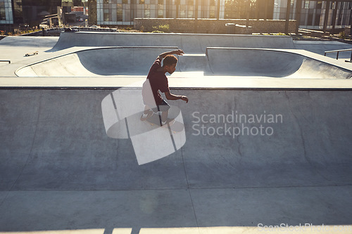 Image of Speed and balance is a powerful combo. High angle shot of a young man doing tricks on his skateboard at a skate park.