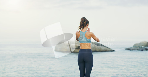 Image of Listening to the waves soothes my restless soul. Rearview shot of an unrecognizable woman standing and doing yoga alone by the ocean during an overcast day.