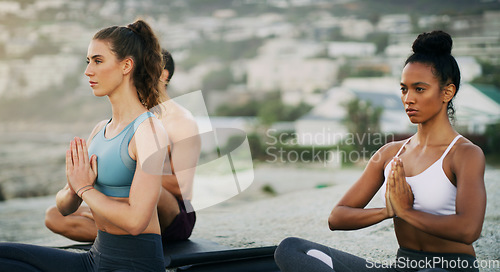 Image of Being able to remain centred is true strength. a group of young people sitting and meditating together while on the beach during an overcast day.