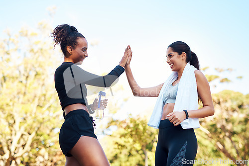 Image of Well done. two attractive young women giving each other a high-five after their run in the park.