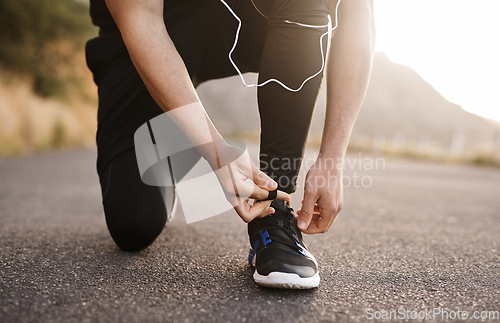 Image of Lacing up to run in the direction of his goals. Closeup shot of an unrecognizable man tying his shoelaces while exercising outdoors.