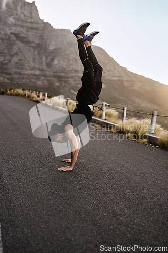 Image of Let me show you how fit and flexible I am. a sporty young man doing a handstand while exercising outdoors.