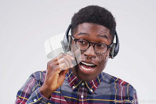 Image of Perfectly skilled at creating an overall positive customer experience. Studio shot of a handsome young male customer service representative wearing a headset against a grey background.