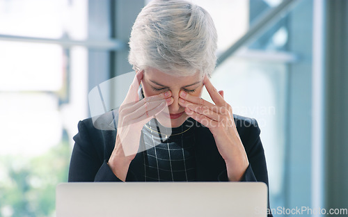 Image of The pressure is mounting. a mature businesswoman looking stressed out while working in an office.