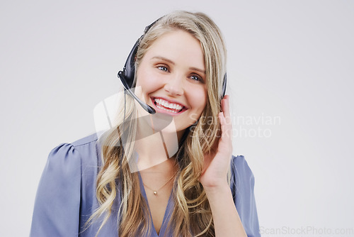 Image of Happy call centre agents make happy customers. Studio shot of an attractive young female customer service representative wearing a headset against a grey background.