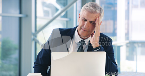 Image of I cant think straight with this headache. a mature businessman looking stressed out while working in an office.