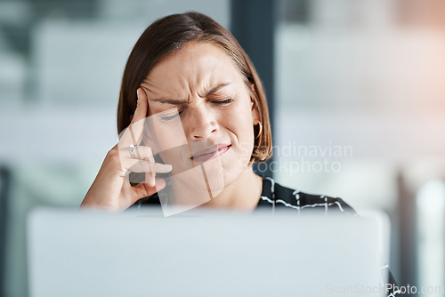 Image of I cant deal with this pain. a young businesswoman suffering with a headache while working in an office.
