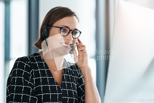 Image of Making happy business calls. a happy young call centre agent working in an office.