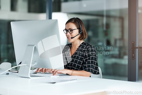 Image of Shell work swiftly to resolve your issues. a happy young call centre agent working on a computer in an office.