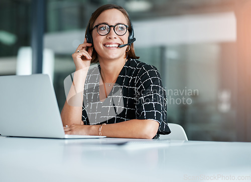 Image of Listening is a crucial part of her job. a happy young call centre agent working on a laptop in an office.