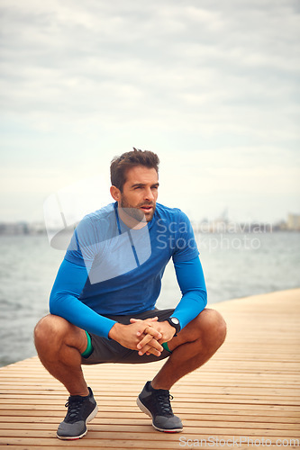 Image of I just need a quick breather. a sporty man taking a break after his run.