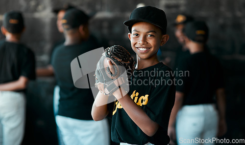 Image of I just love baseball. Portrait of a young baseball player wearing baseball mitts with his teammates standing in the background.