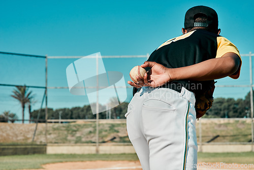 Image of This will settle the score. Rearview shot of a baseball player holding the ball behind his back.