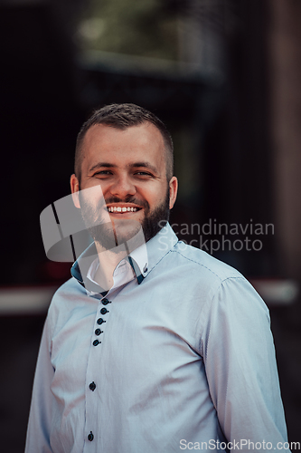 Image of A portrait of a modern man, exuding confidence and style, against an outdoor backdrop, showcasing his charisma and fashionable demeanor.