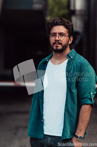 Image of A portrait of a modern man, exuding confidence and style, against an outdoor backdrop, showcasing his charisma and fashionable demeanor.