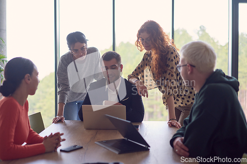 Image of A diverse group of business professionals gathered at a modern office for a productive and inclusive meeting