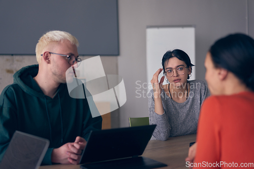 Image of A diverse group of business professionals gathered at a modern office for a productive and inclusive meeting